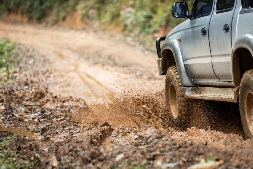 SUV terepjáró 4wd-s autó sáros pocsolyában.