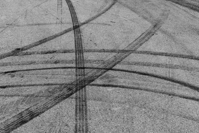 Fekete gumiabroncs jelek aszfalton.