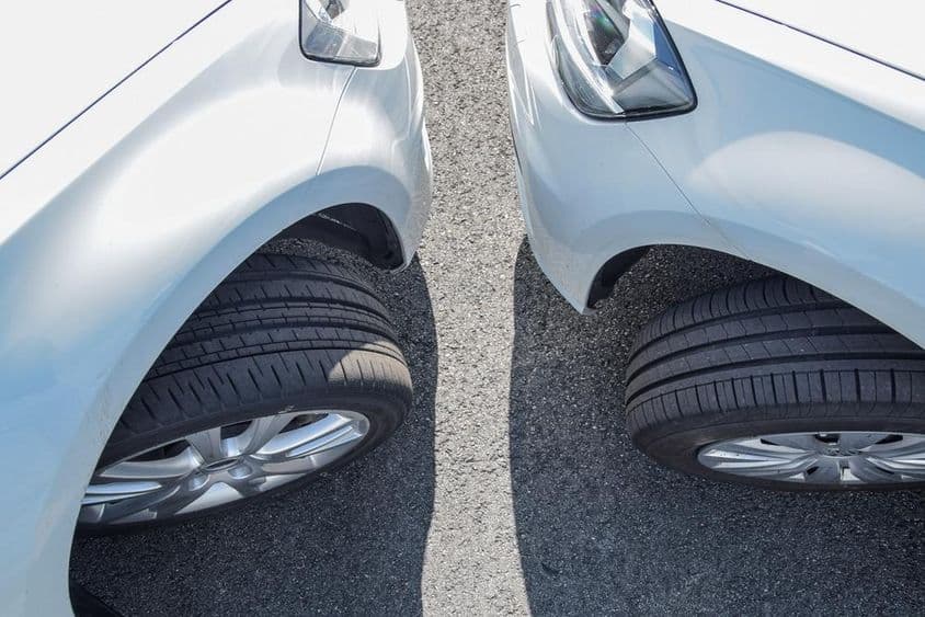 Két fehér VW Golf parkol egymáshoz közel, más gumiabroncsokon.