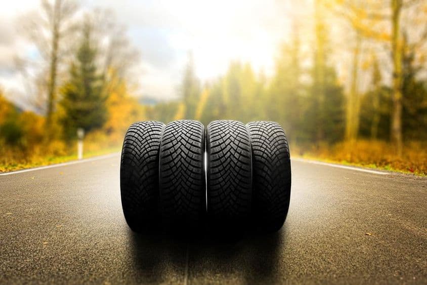 Szezonális autógumi csere napsütéses úton.