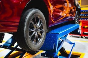 Egy kocsit emelnek fel az emelővel.