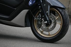 Yamaha Matic Nmax ezüst színű parkol a városban.