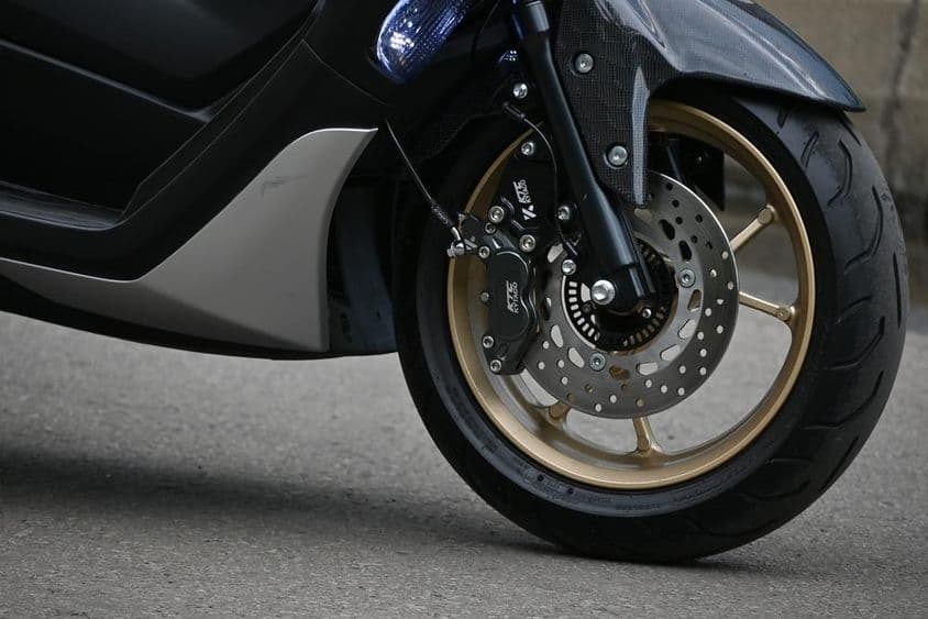 Yamaha Matic Nmax ezüst színű parkol a városban.