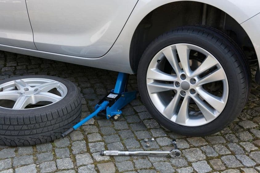 Kerékcsere emelővel egy modern autón.
