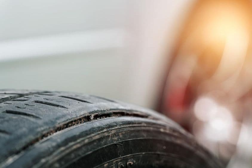 Elhasználódott gumiabroncs látható sérülésekkel.