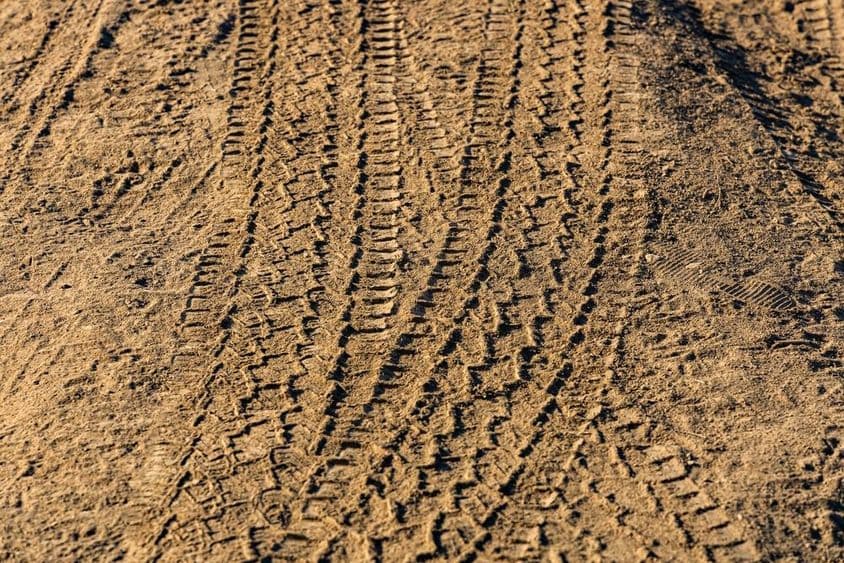 Keréknyomok egy poros vidéki úton.